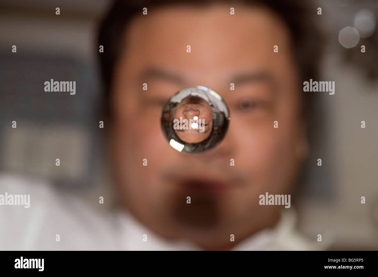 Astronaut Leroy Chiao, Expedition 10 commander and NASA ISS science officer, watches a sphere of water float between him and the Stock Photo