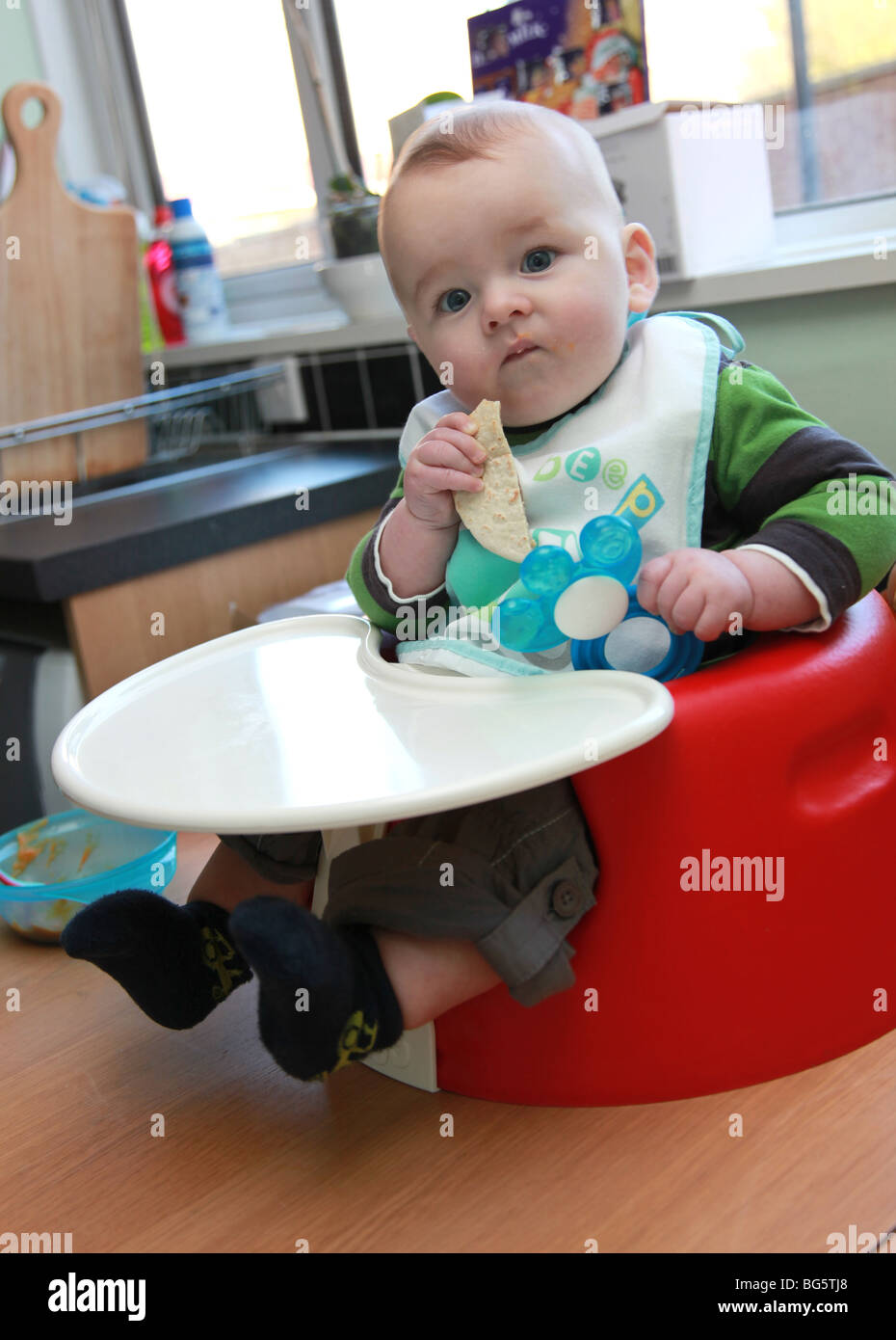 Baby in bib having lunch Stock Photo - Alamy