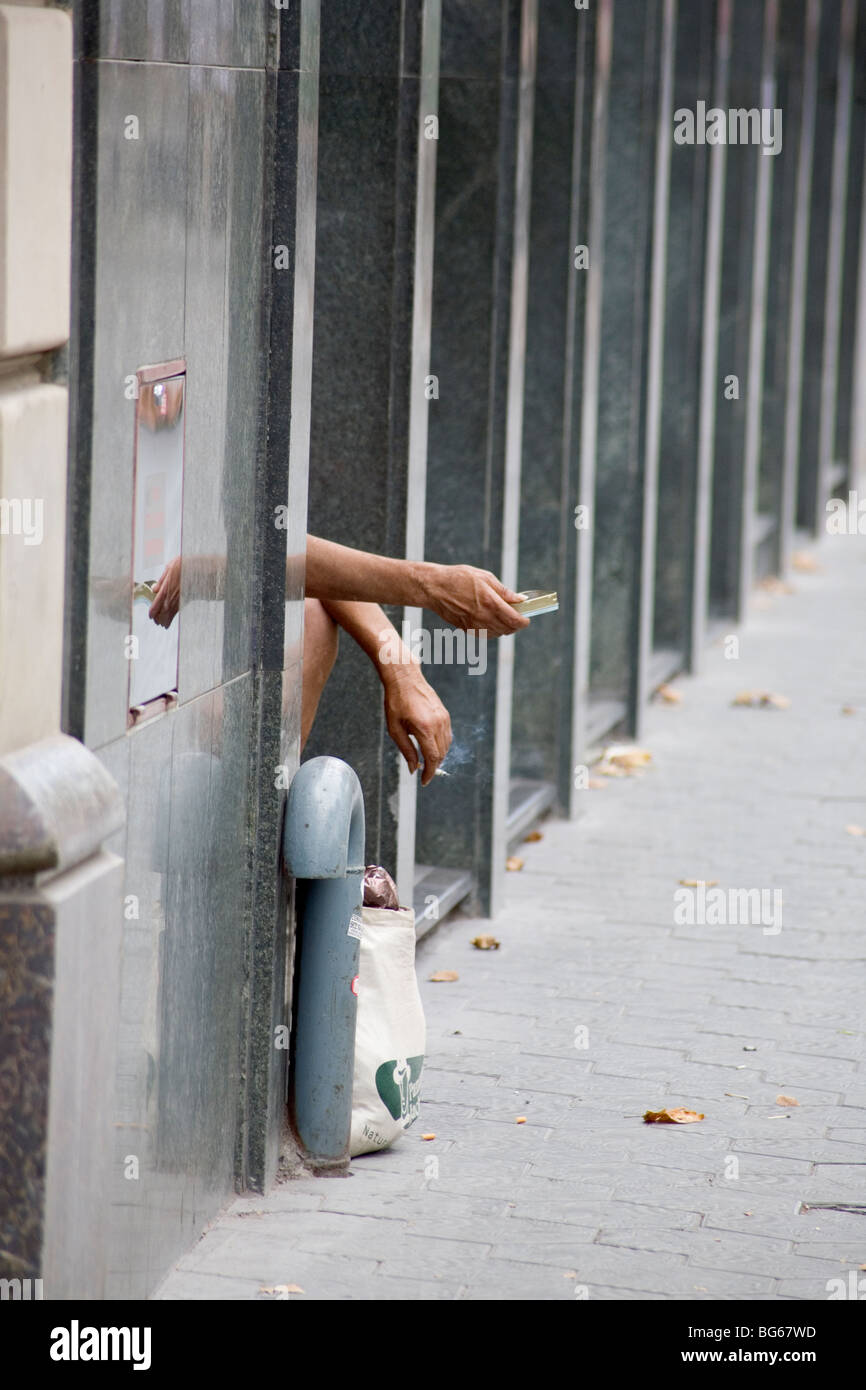 Street beggar collecting and smoking on Passeig de Gracia Barcelona Catalonia Spain Stock Photo