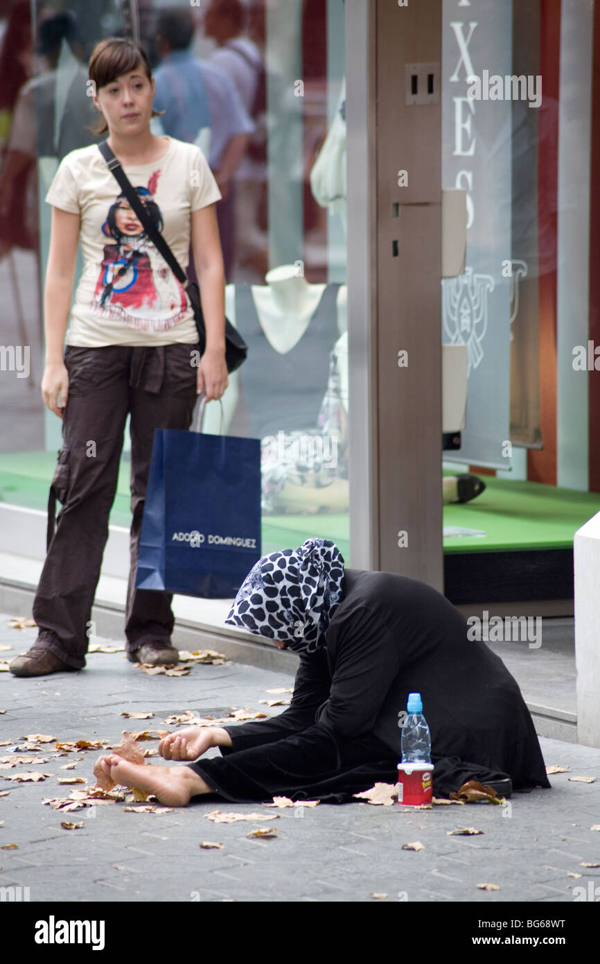 Street beggar outside upmarket boutique on Passeig de Gracia Barcelona Catalonia Spain Stock Photo