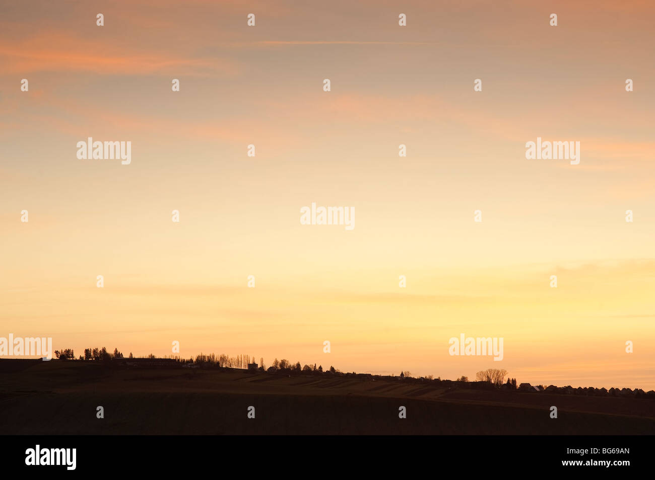 Morning horizon with a village silhouethe and yellow orange sky Stock Photo