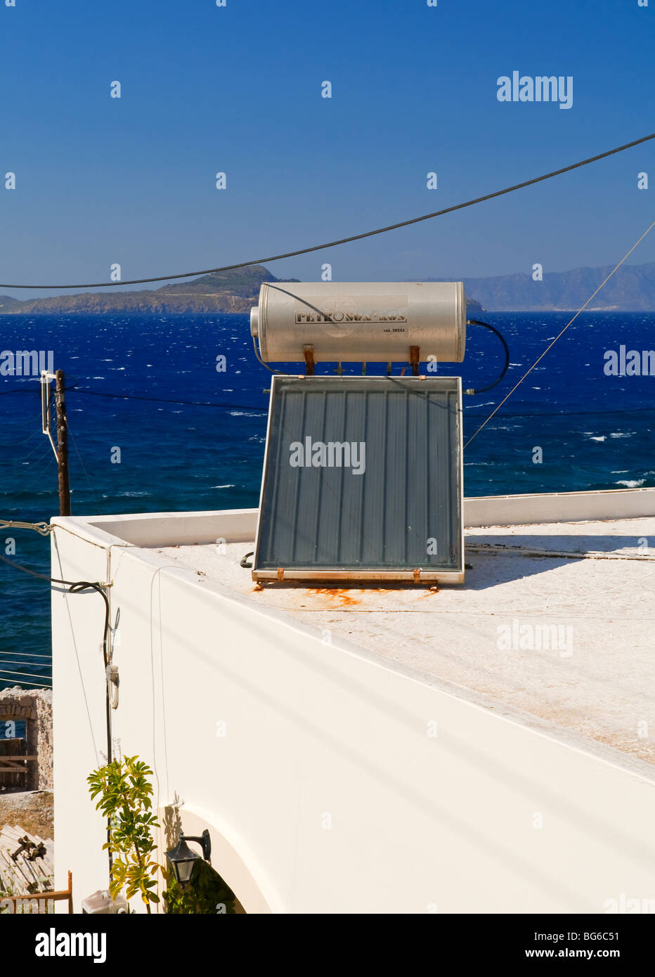Solar powered domestic water heating system with solar panel and tank on the roof of a house in Greece Stock Photo