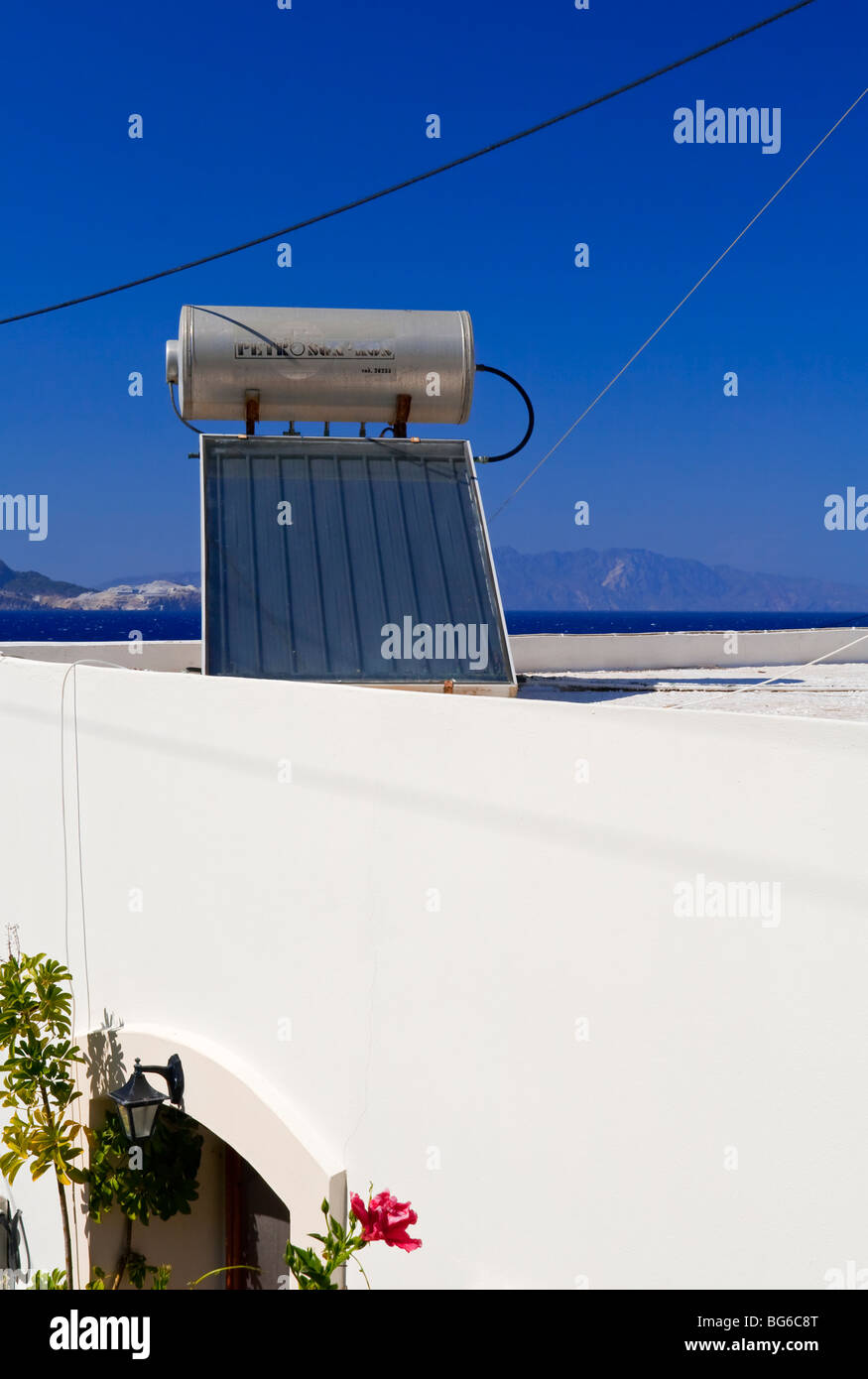 Solar powered domestic water heating system with solar panel and tank on the roof of a house in Greece Stock Photo