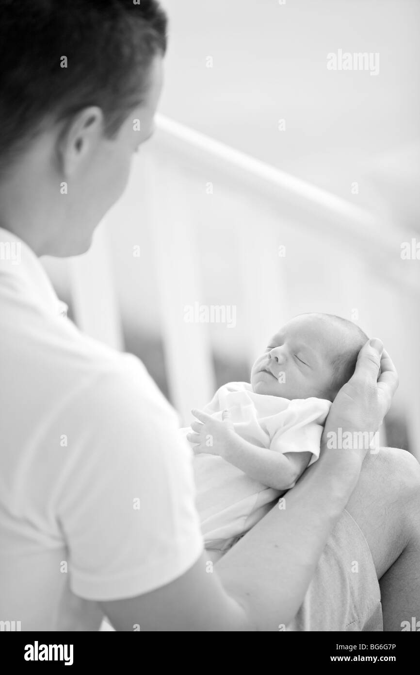 Newborn baby sleeping in father's arms Stock Photo Alamy