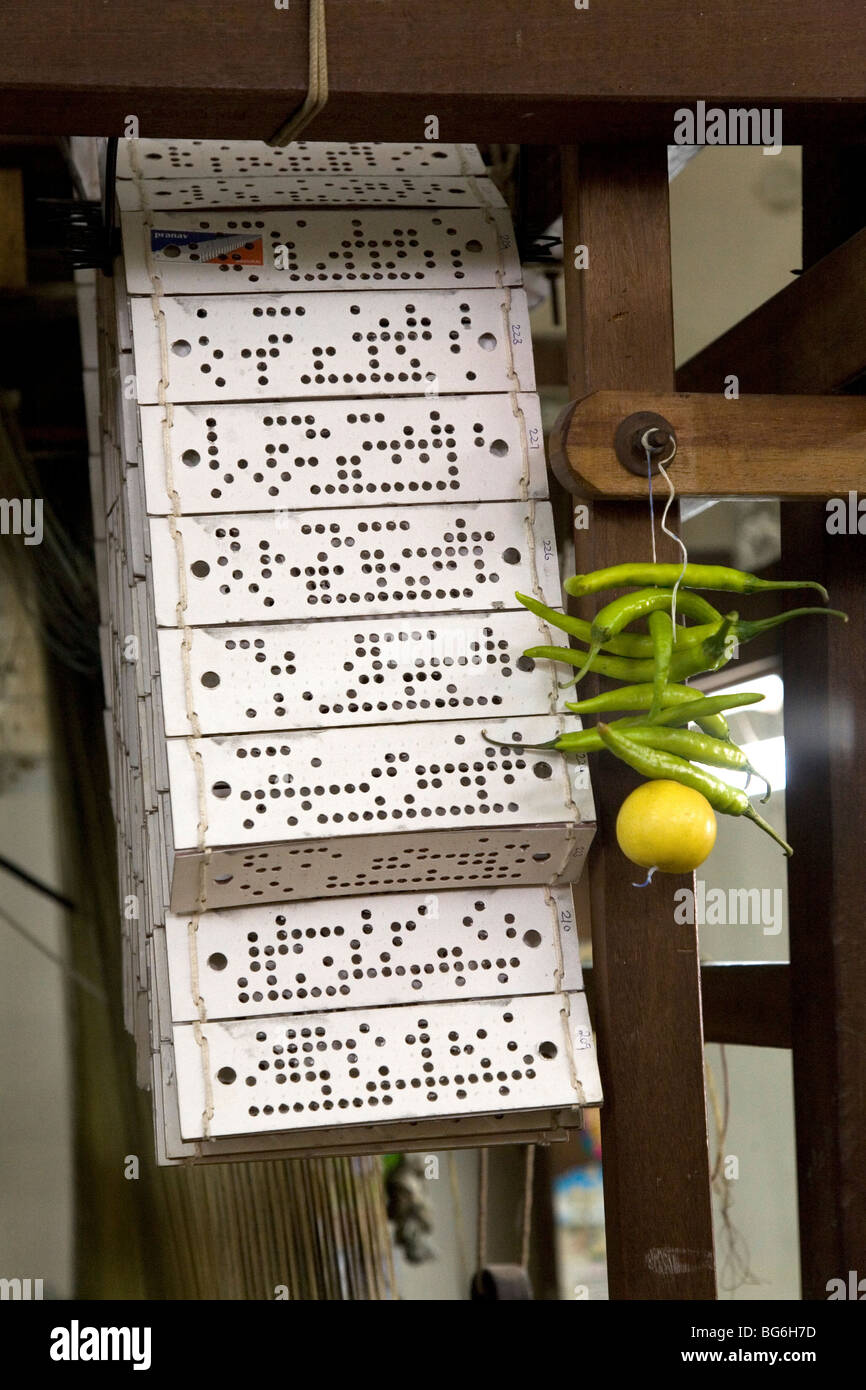 Punched cards hang from the frame of silk weaving loom in Kanchipuram, India. Stock Photo