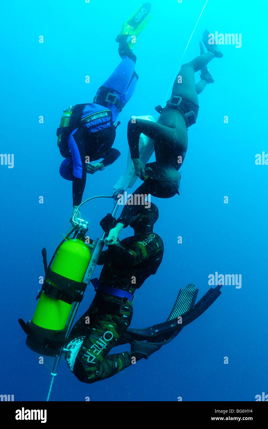 Group of free divers going down with a weighted tank in the Mediterranean Sea, off Monaco Stock Photo