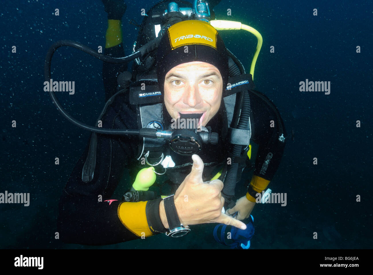 Scuba diver with no mask doing the 'shaka' sign in the Mediterranean Sea Stock Photo