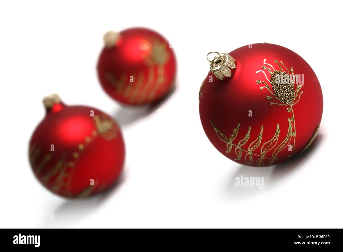Three Red Christmas Balls Isolated On White Background. Tilt view, shallow DOF. Stock Photo