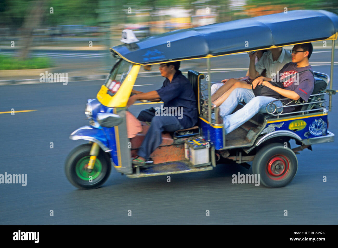 tourists in a three wheeled tuk tuk taxi, Bangkok, Thailand Stock Photo