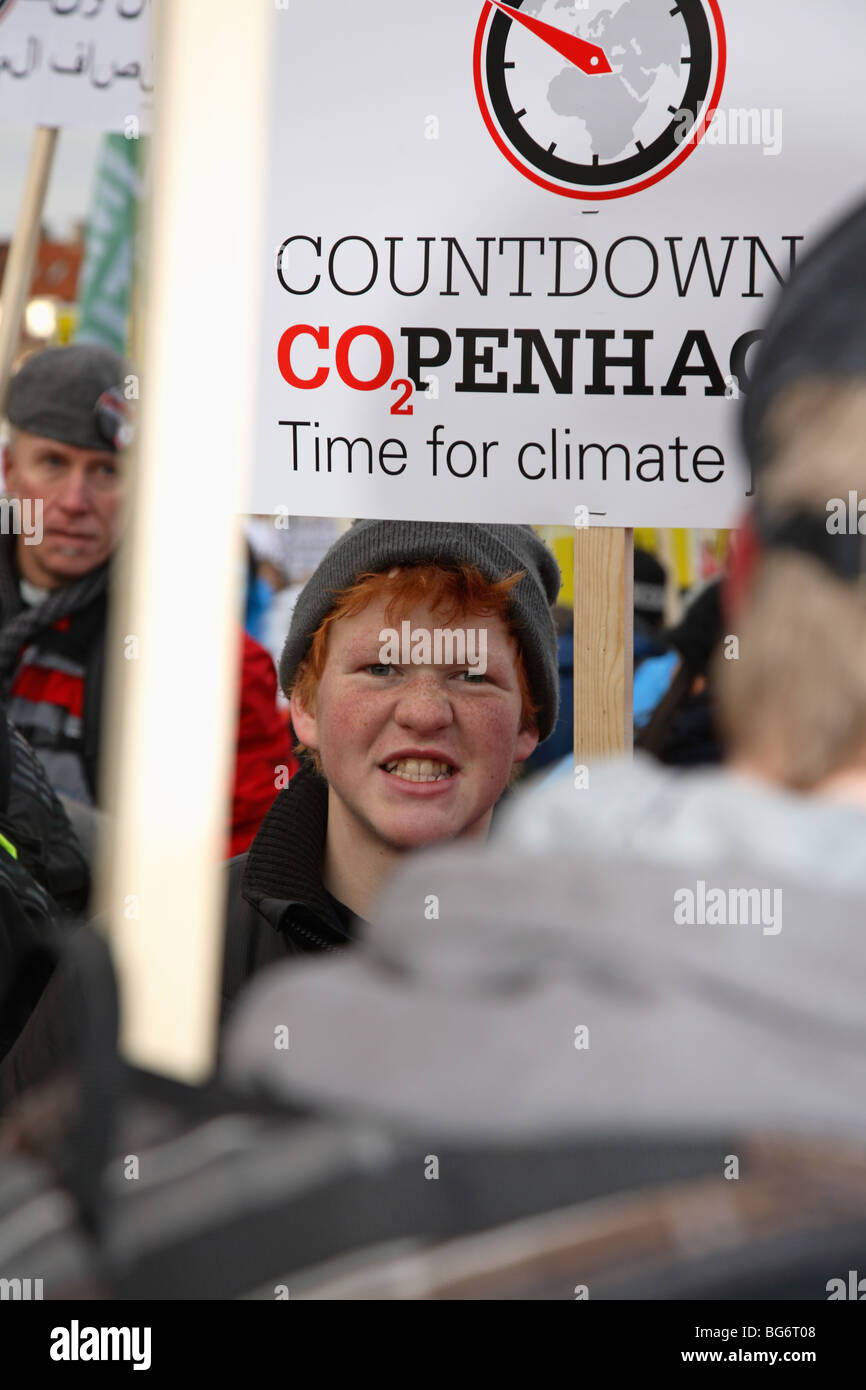 Determined teenager in large demonstration in front of the Parliament building in Copenhagen at the UN Climate Change Conference. Climate march. Stock Photo