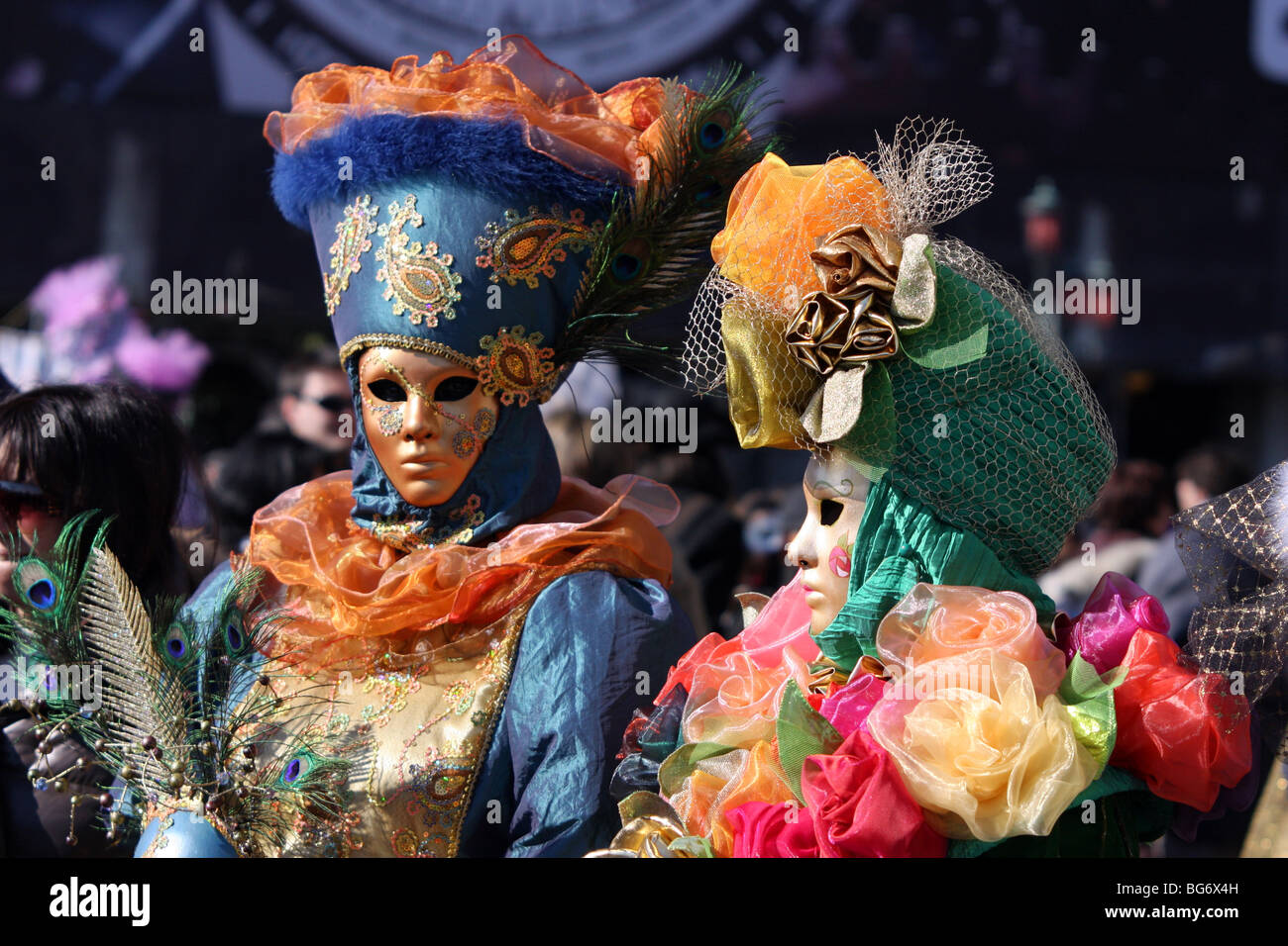 Couple of Venetian people wearing colourful masks and costumes Stock Photo
