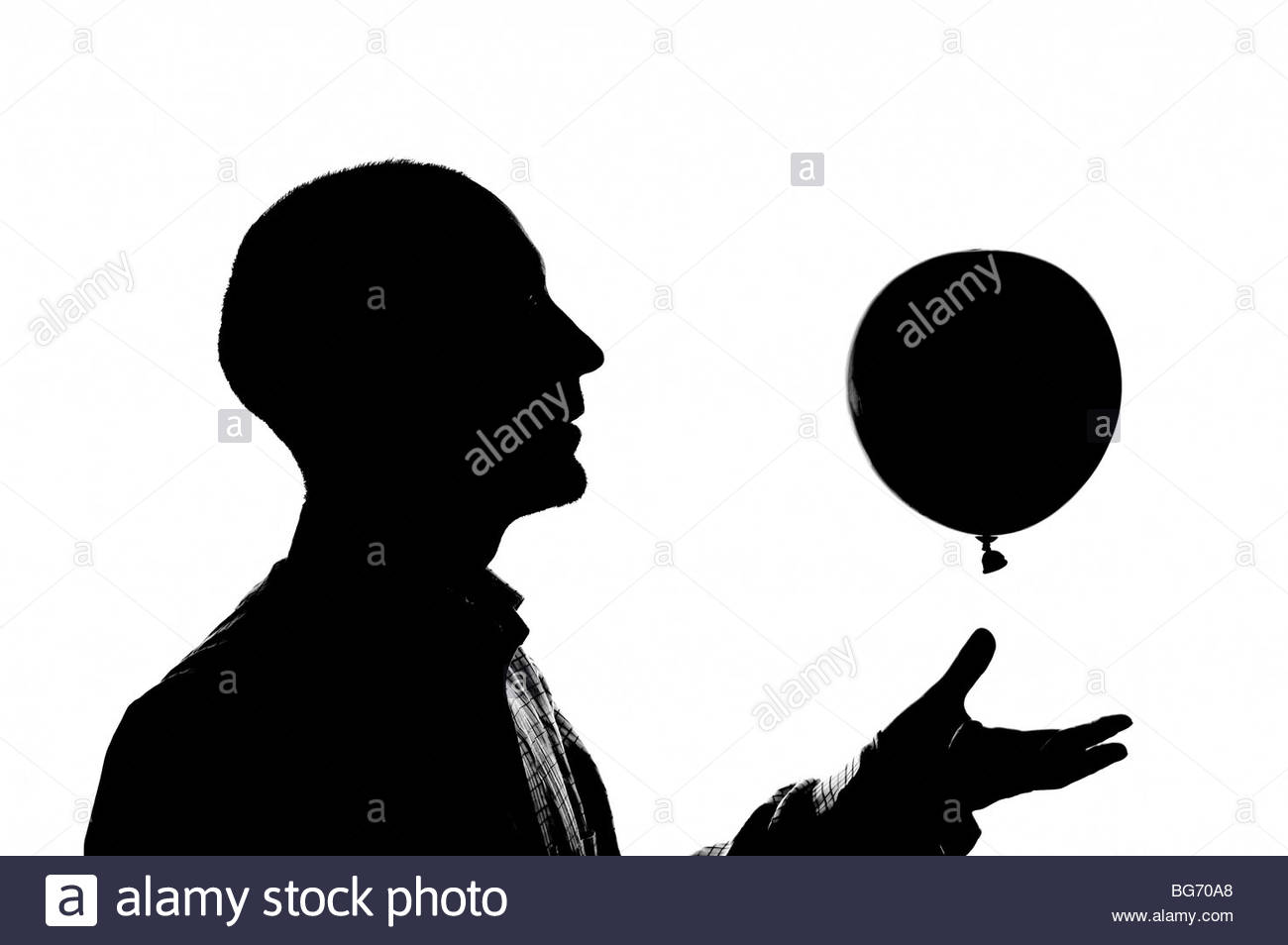 Silhouetted man with balloon Stock Photo