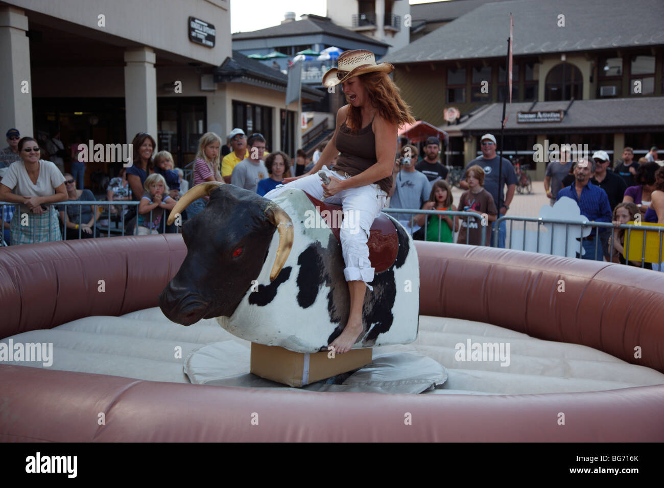 Woman riding a mechanical bull Stock Photo