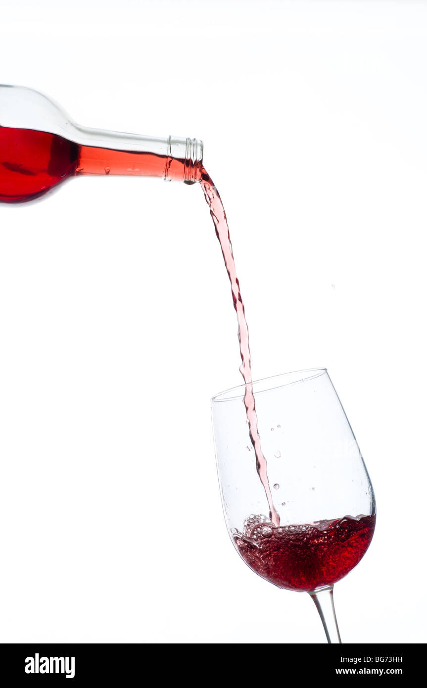 red wine being poured into wineglass from bottle Stock Photo