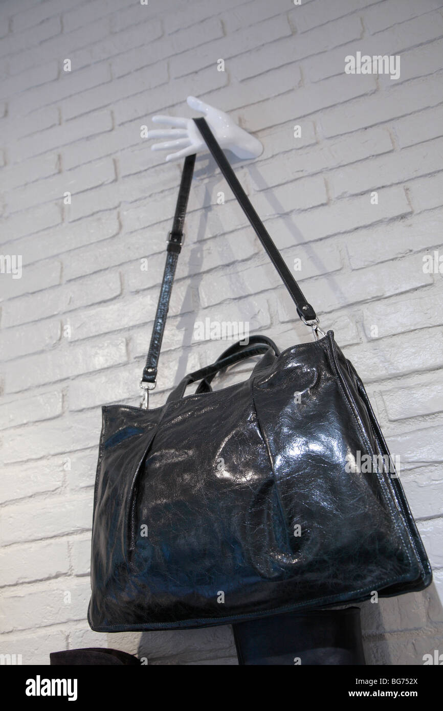 womans leather shoulder bag hanging on wall in shop Stock Photo Alamy