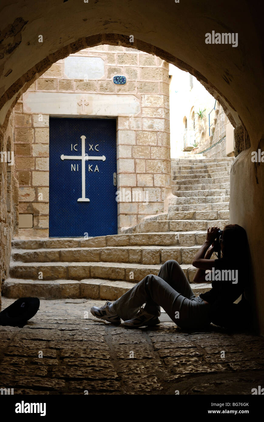 Israel, Tel Aviv, Jaffa, people in a Narrow alleyway next to the door to the Greek Orthodox Church Stock Photo