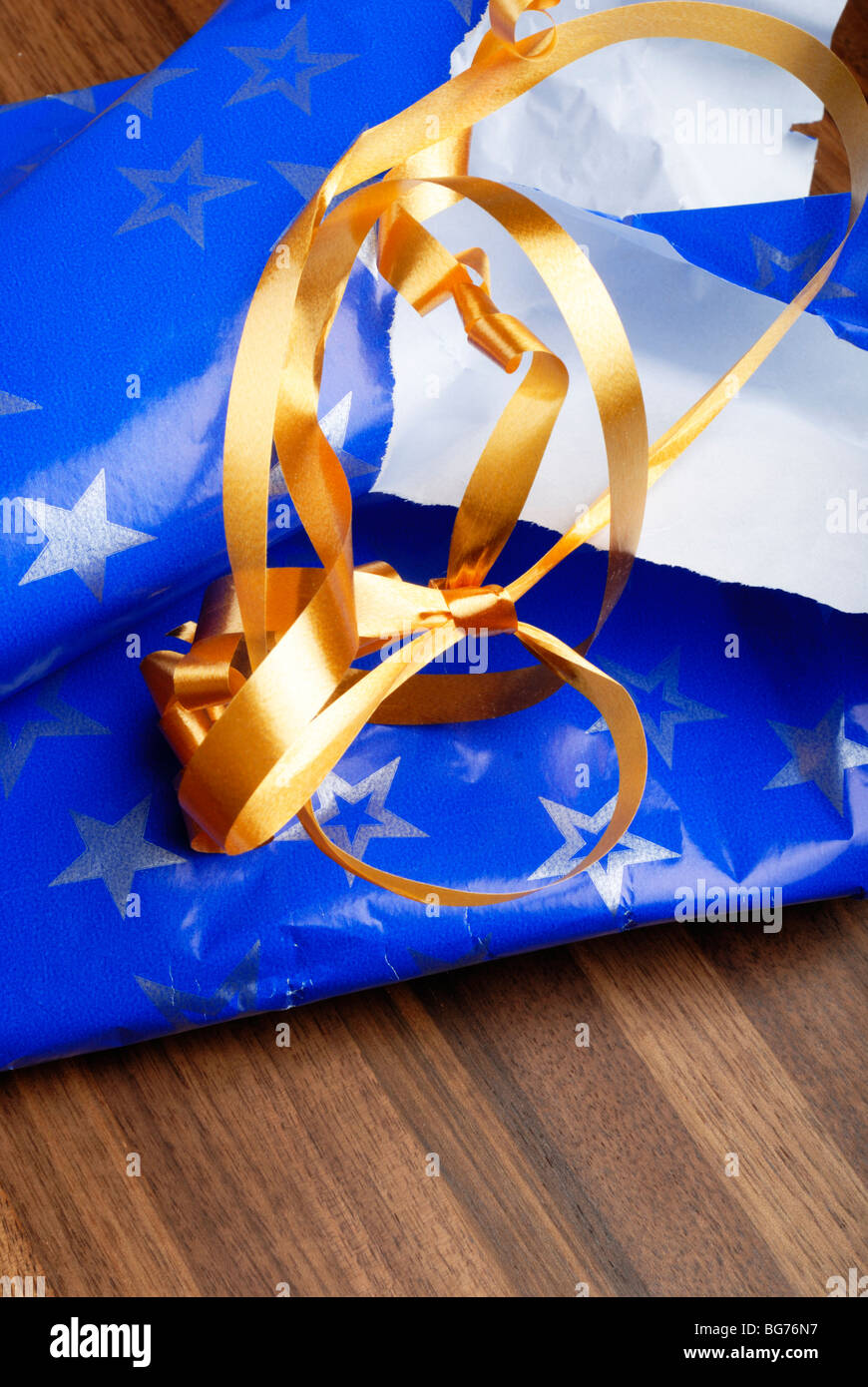 Torn gift wrapping on floor Stock Photo