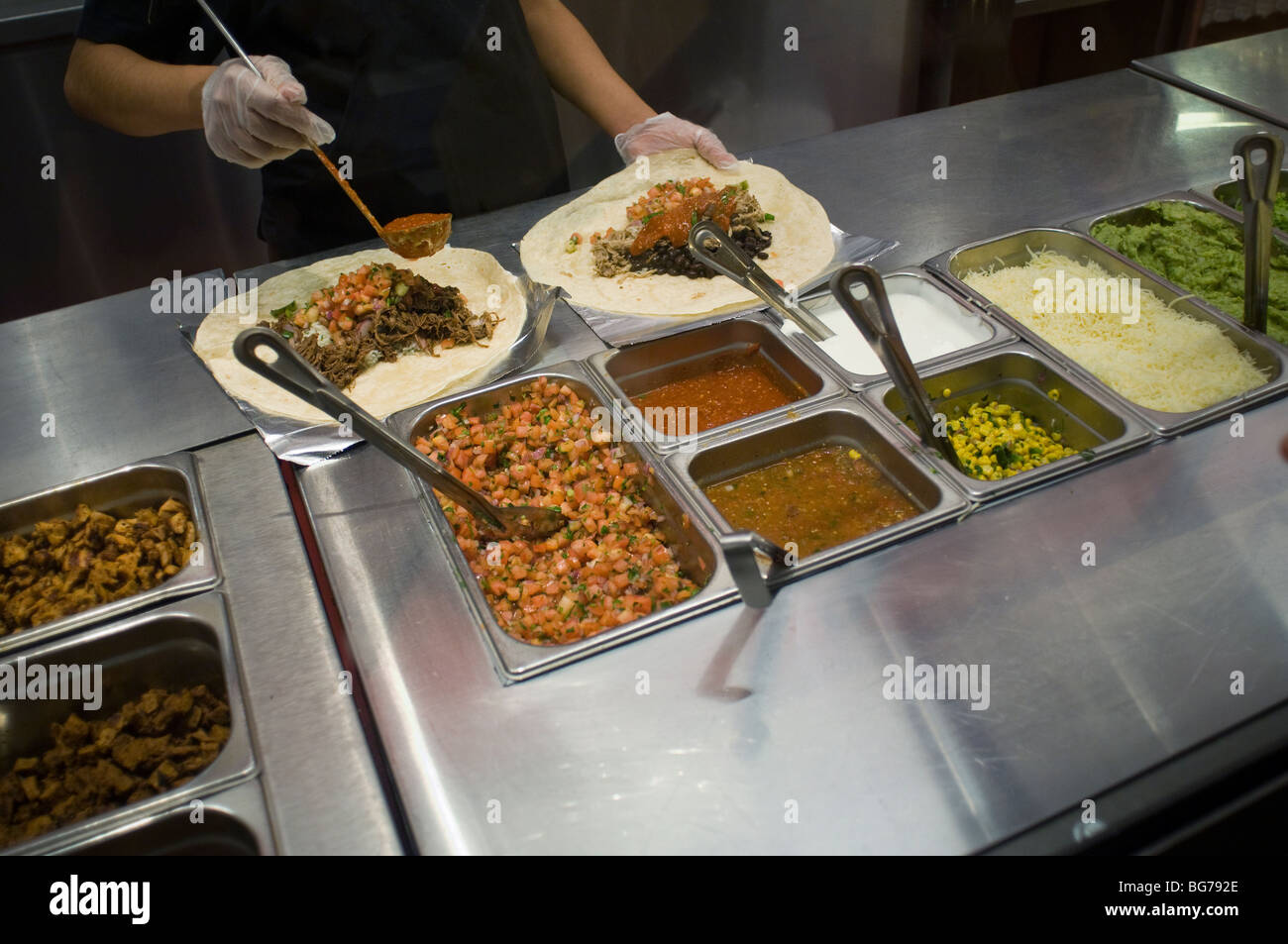 Workers prepare burritos at a Chipotle Mexican Grill in Midtown in New York Stock Photo