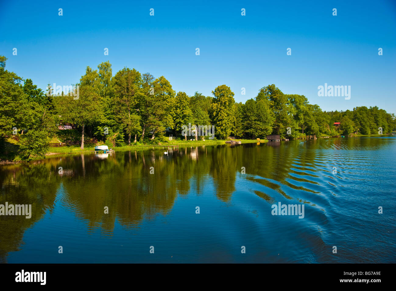 Coast with trees and homes at lake along Elblaski Canal near Elblag