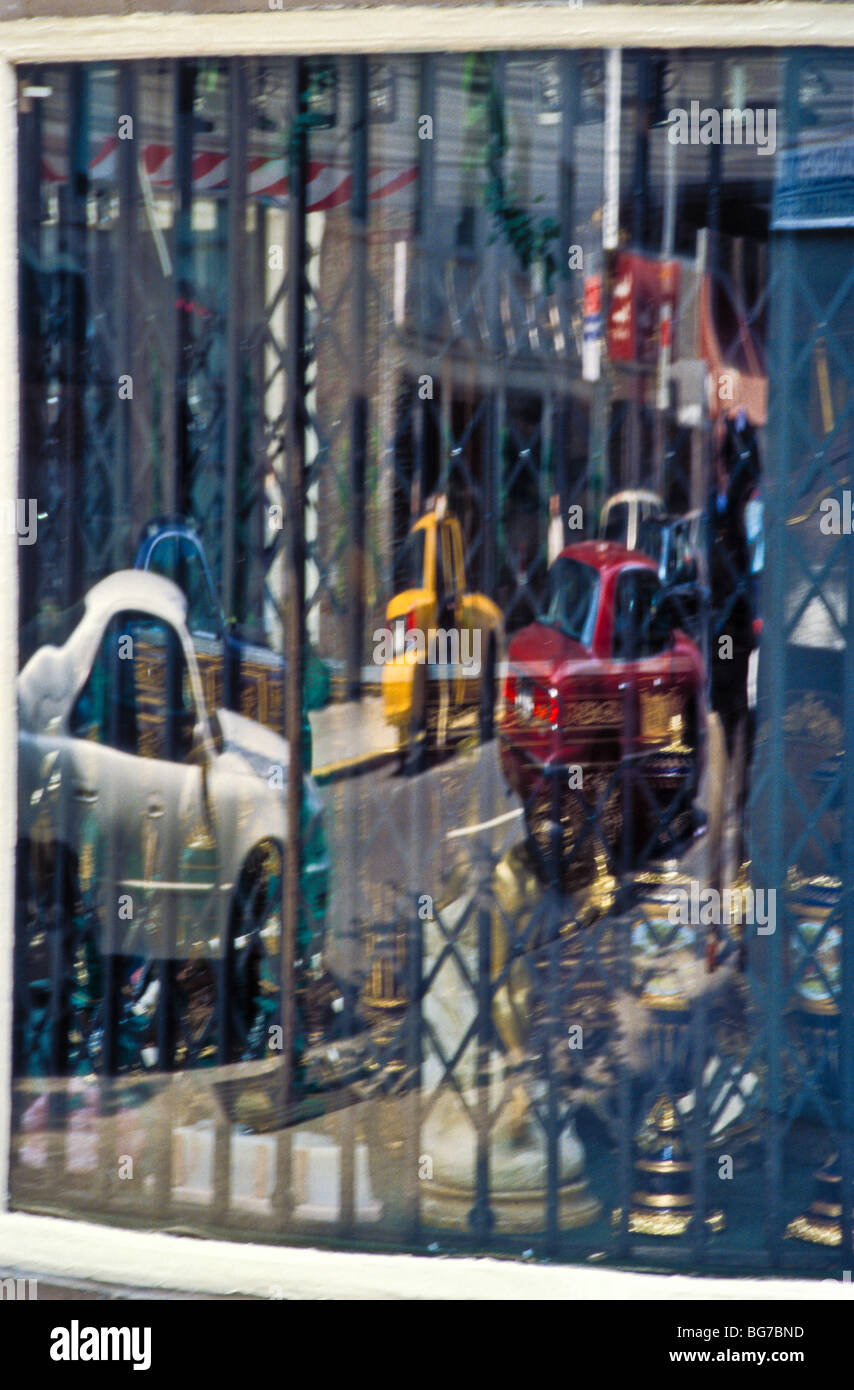 reflections in store window with security gate Stock Photo - Alamy