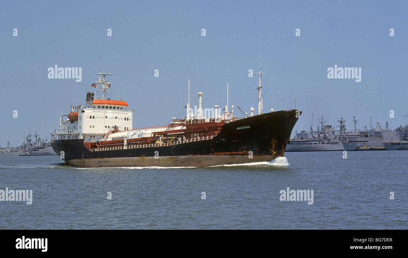 The large Brazilian oil tanker Amazonia sails by the destroyers and aircraft carriers at the Norfolk Navy Base, in Norfolk, Virginia. Stock Photo