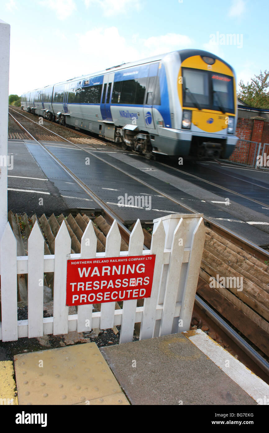 The Northern Ireland railways Enterprise service at the level crossing at Moira station, County Down, Northern Ireland Stock Photo