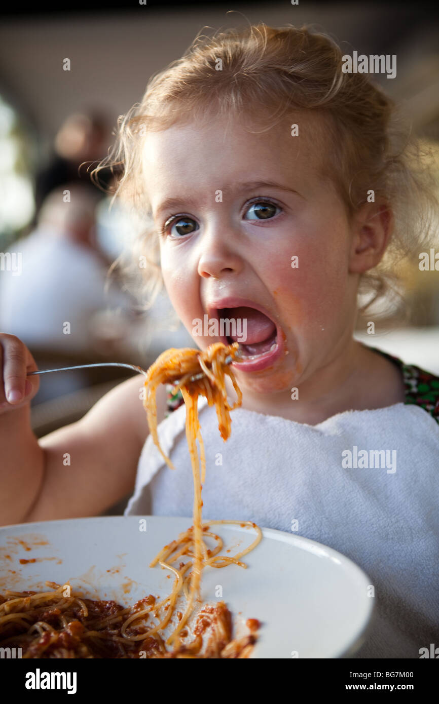 cute little girl is eating spagetti spaghetti Stock Photo