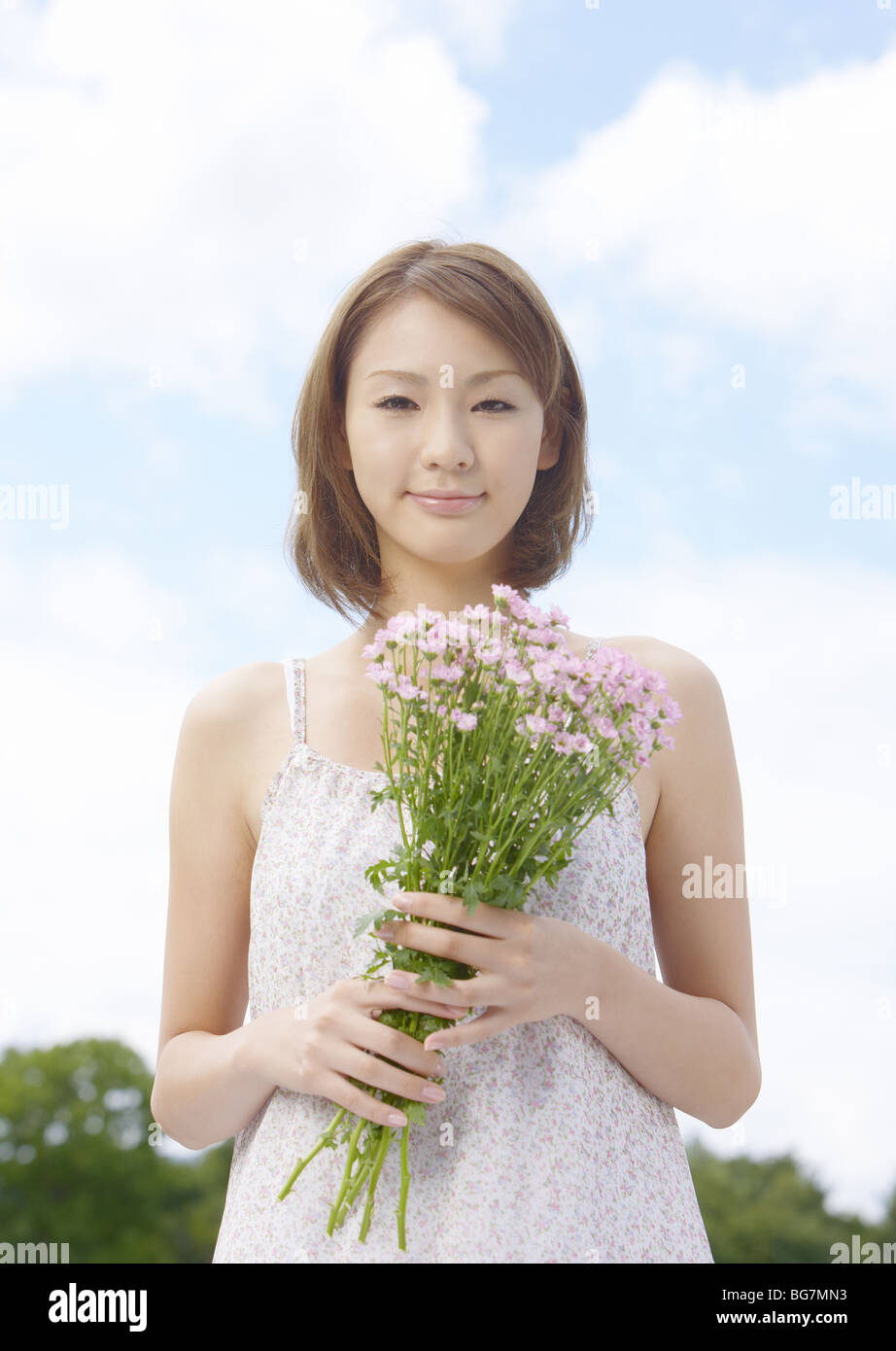 A young woman holding a bouquet Stock Photo - Alamy