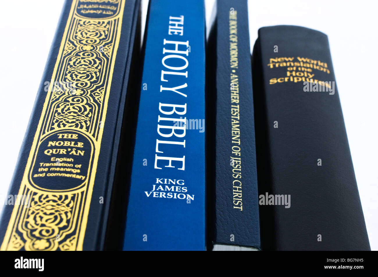 Stack of holy books - New World Translation of the Holy Scriptures, Book of Mormon, Holy Bible and the Qu'ran Stock Photo