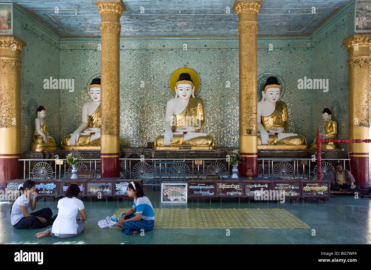 Burmese women  and Buddha statues. Shwemawdaw Paya. Bago. Myanmar. Stock Photo
