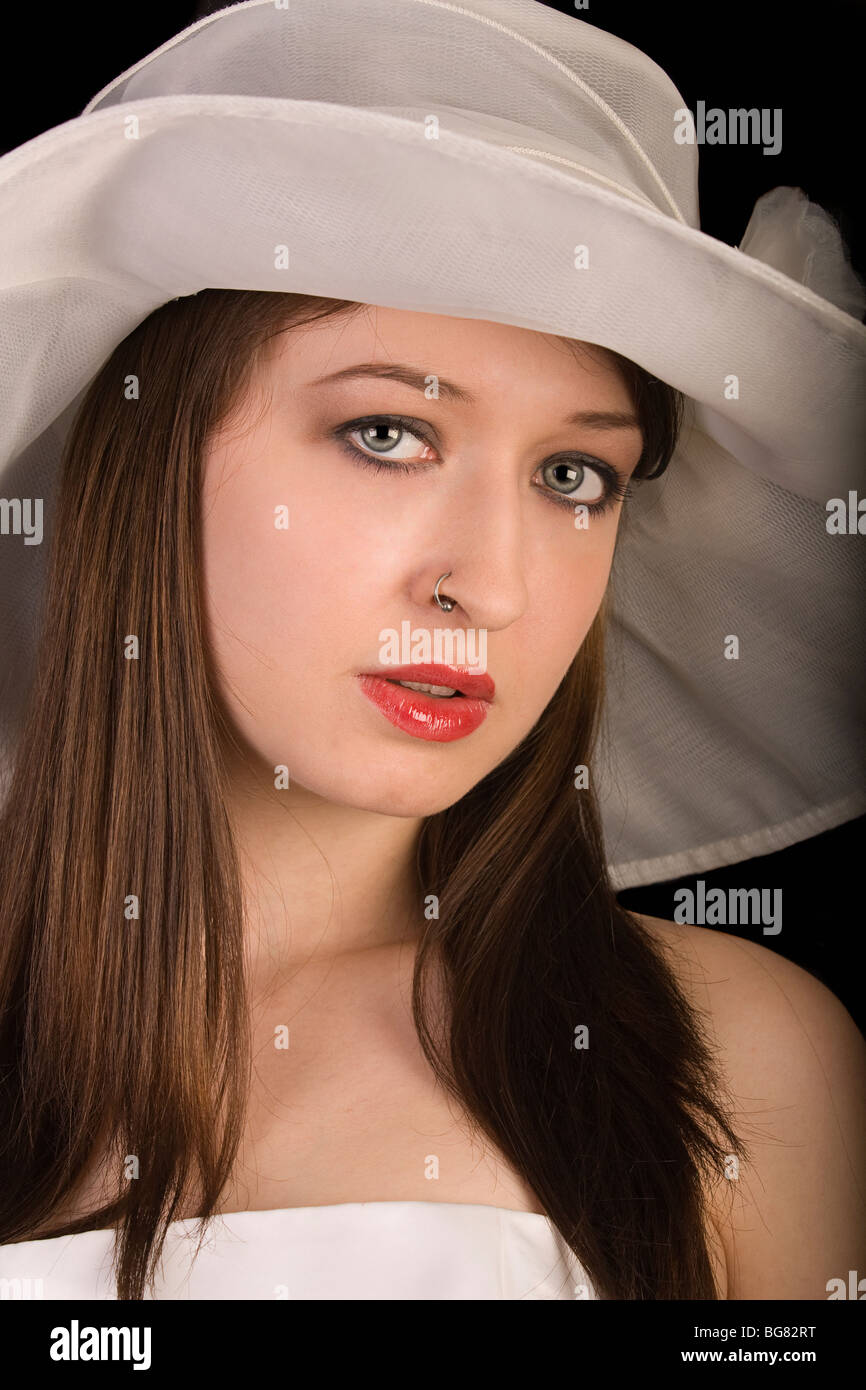 a beautiful young woman with a nose-ring and an ascot hat Stock Photo