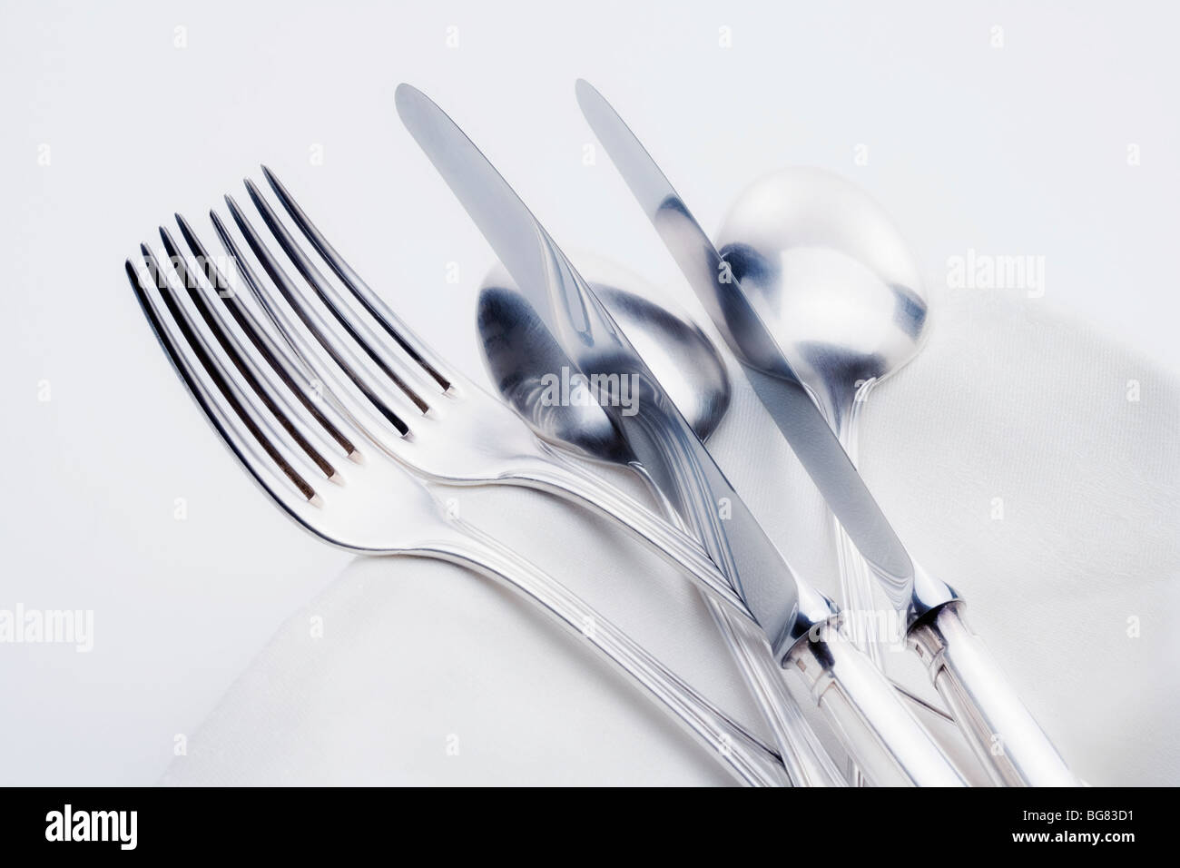 silverware - closeup of elegant knife fork and spoon on white cloth Stock Photo