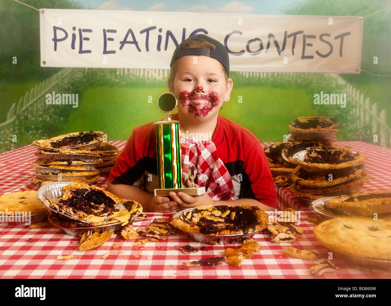 Chubby Boy at the end of a pie eating contest with the winning medal Stock Photo