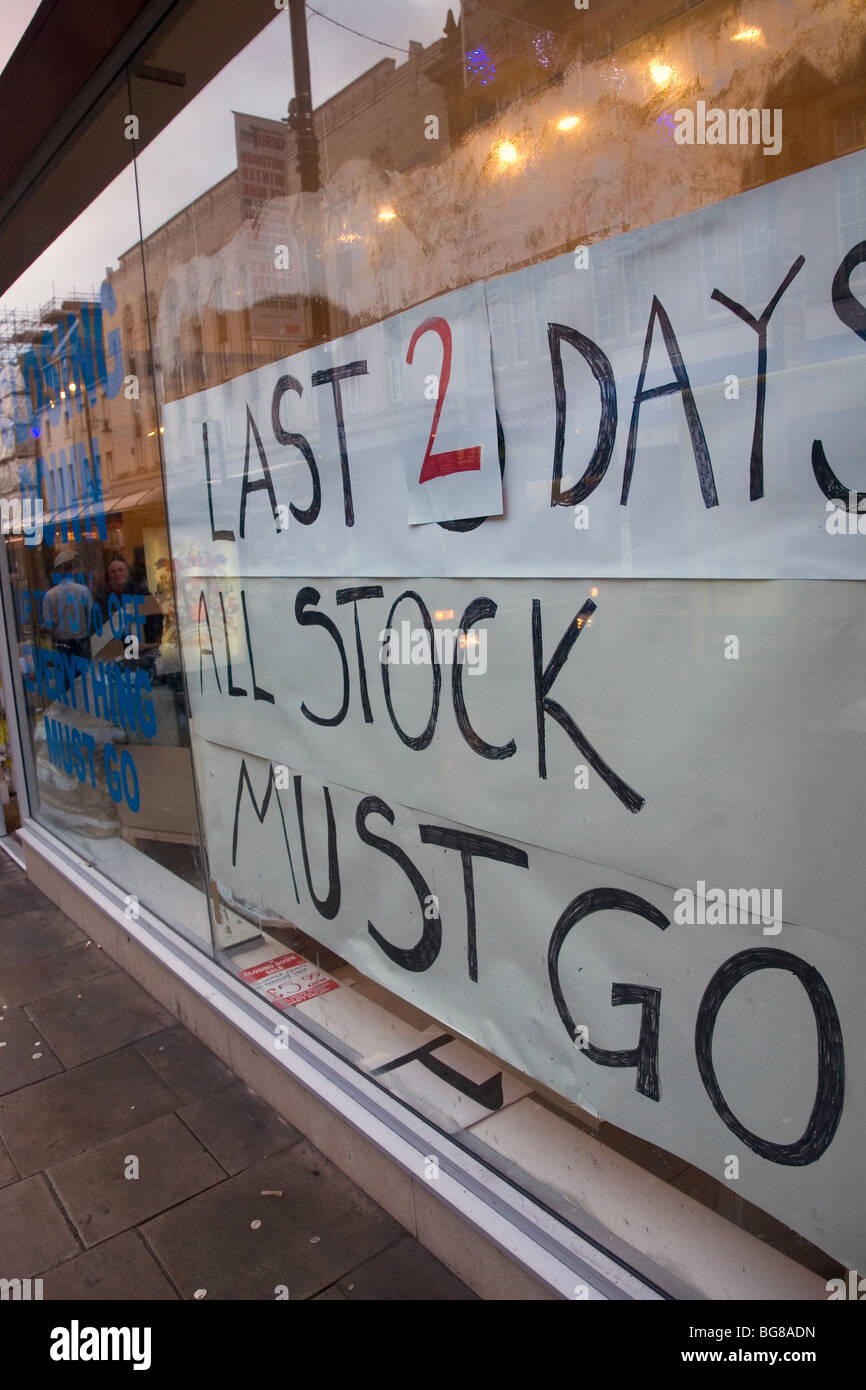 A shop announces that it will close and is holding a closing down sale. The sign states that in just 2 days 'all stock must go'. Stock Photo