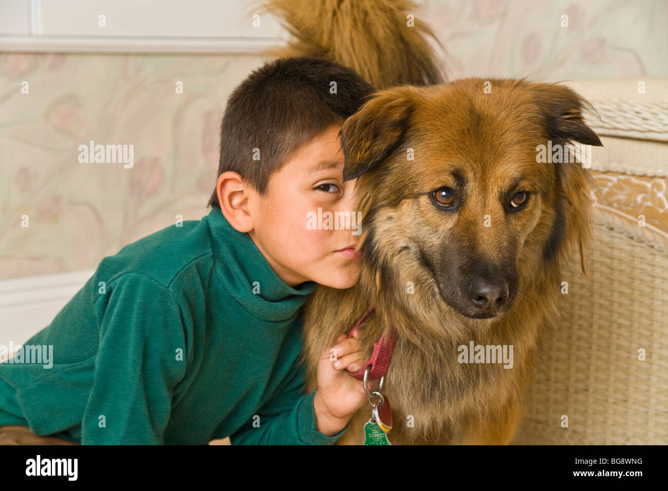 6-7 year old Hispanic boy being affectionate with his dog. child playing play plays dog eye level close up  front view MR  © Myrleen Pearson Stock Photo