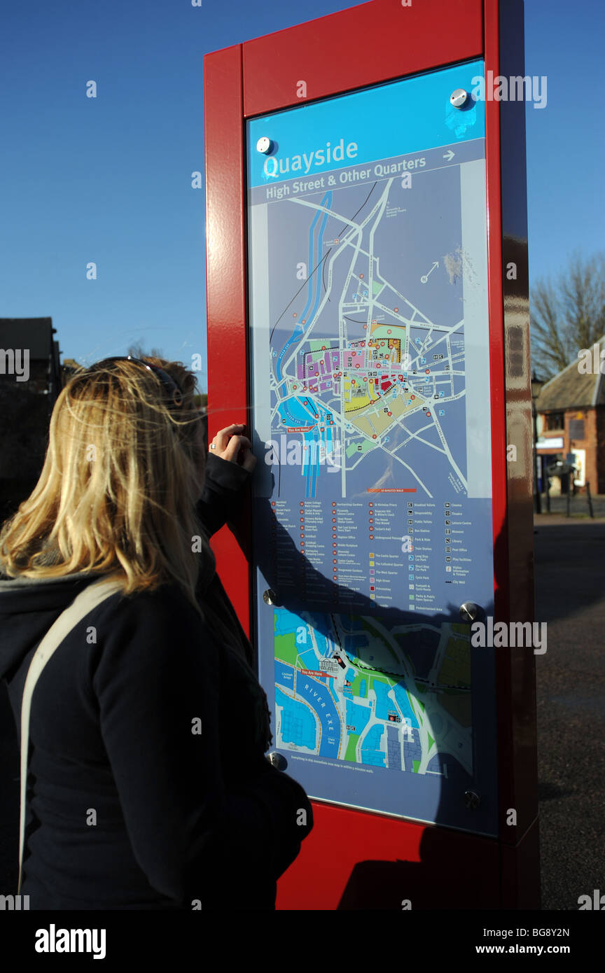 A woman looks at the information board and map on the quayside in exeter Stock Photo