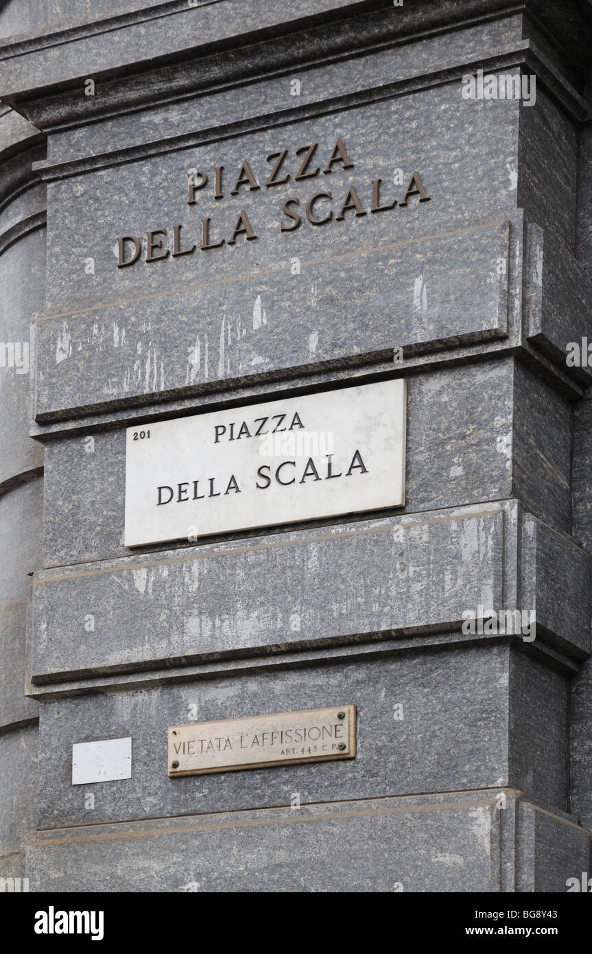 Street sign reading PIAZZA DELLA SCALA with second sign reading VIETATA LA AFFISIONE Milan Milano Italy Italia Stock Photo