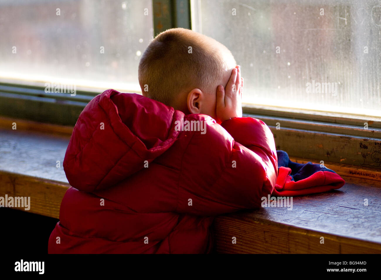 Sad Boy Sitting at Window Stock Photo
