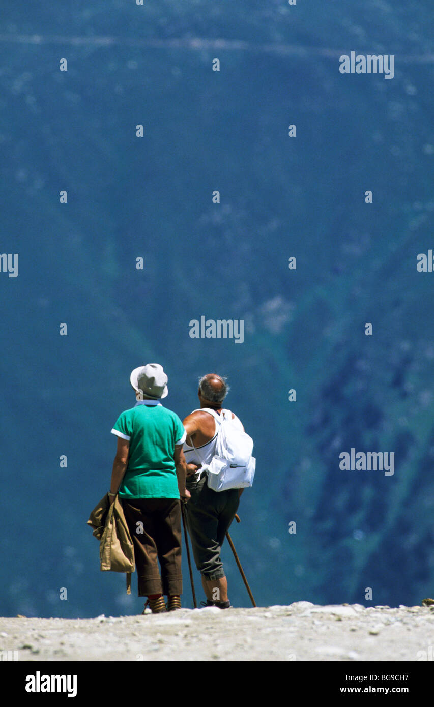 Man and woman stand to admire the mountain view Stock Photo - Alamy