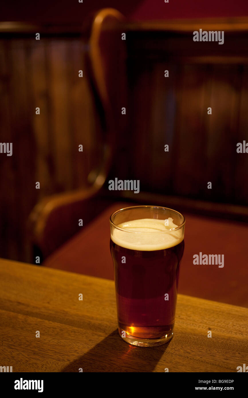 Pint glass of real ale on a pub table. Sales of ales are increasing, where other beer and beverages are declining. Market Porter Stock Photo