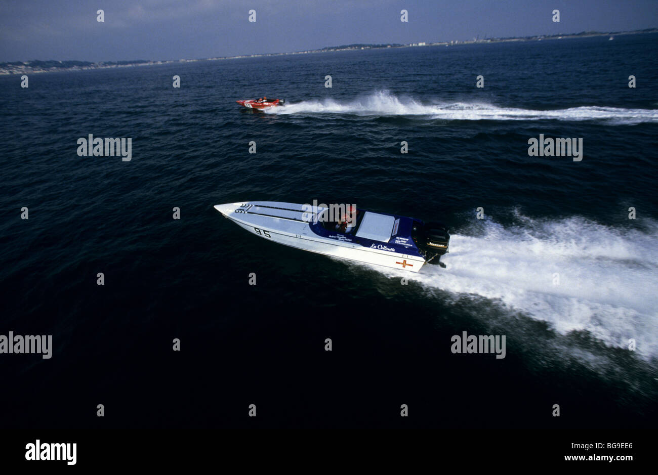 Two multi-pilot  Powerboats  race each other off sea coast Stock Photo