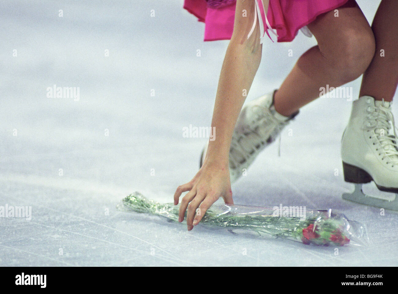 female ice skater picking up flowers after performance Stock Photo Alamy
