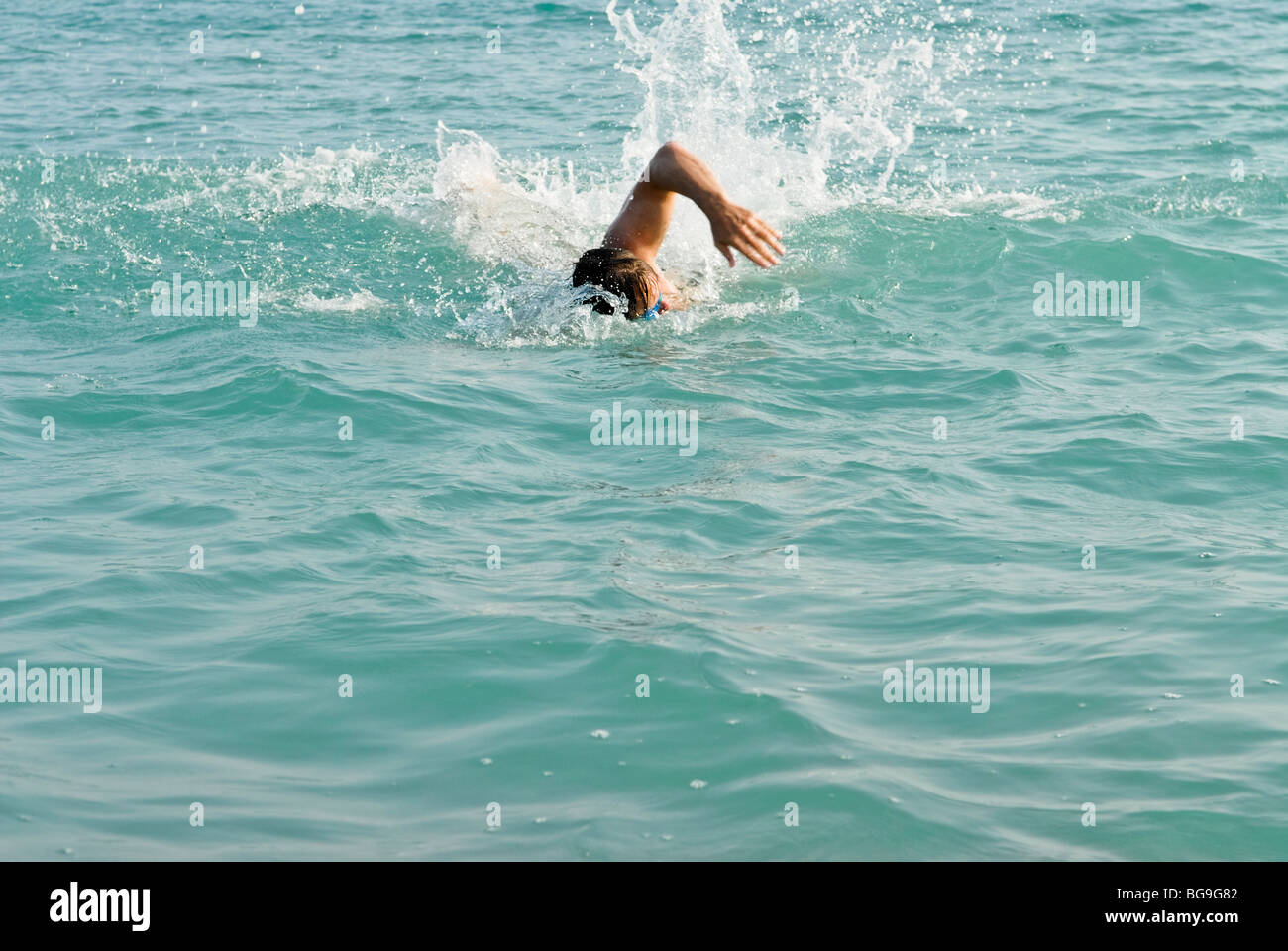 Male swimmer swimming front crawl in the sea. Stock Photo