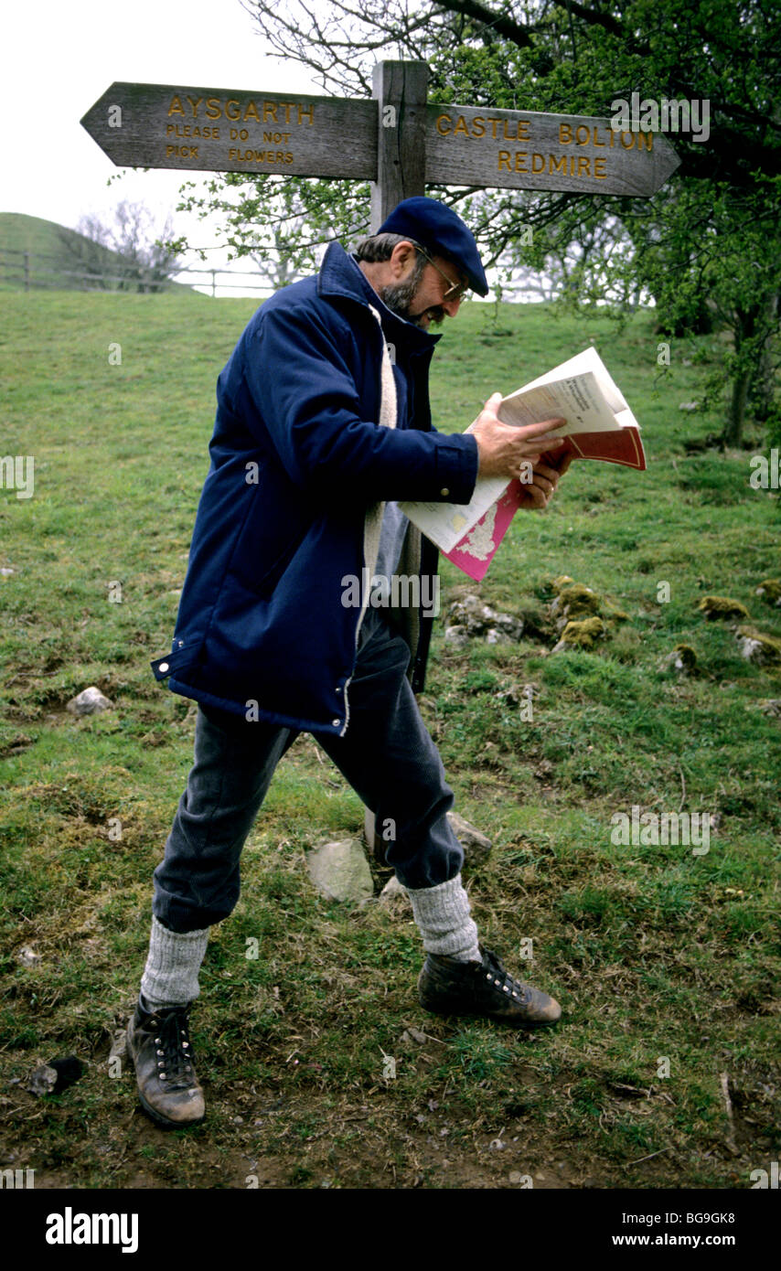 Man reading a map by a rural signpost Stock Photo - Alamy