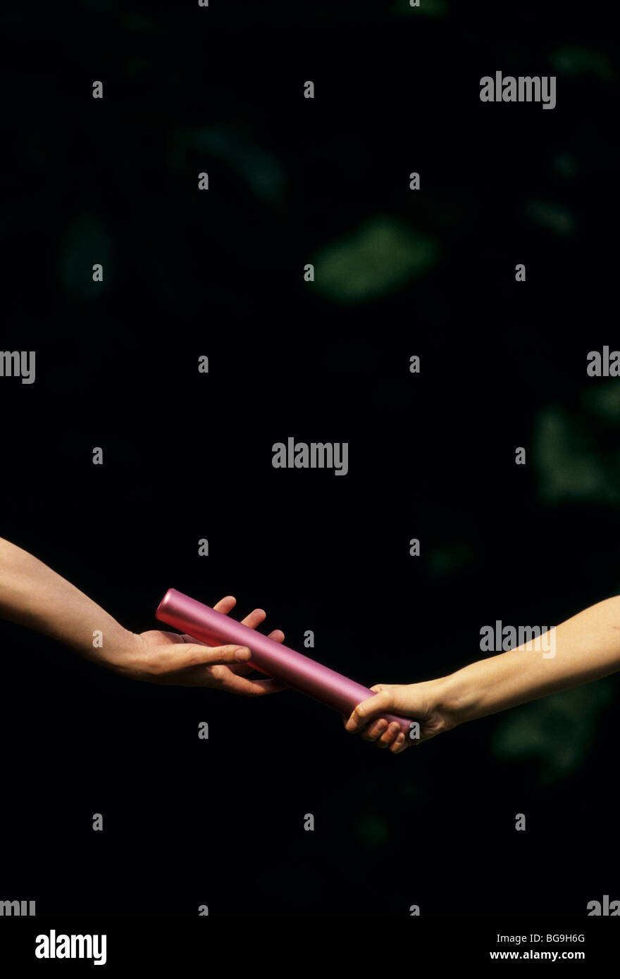 Two athletes passing a baton Stock Photo - Alamy