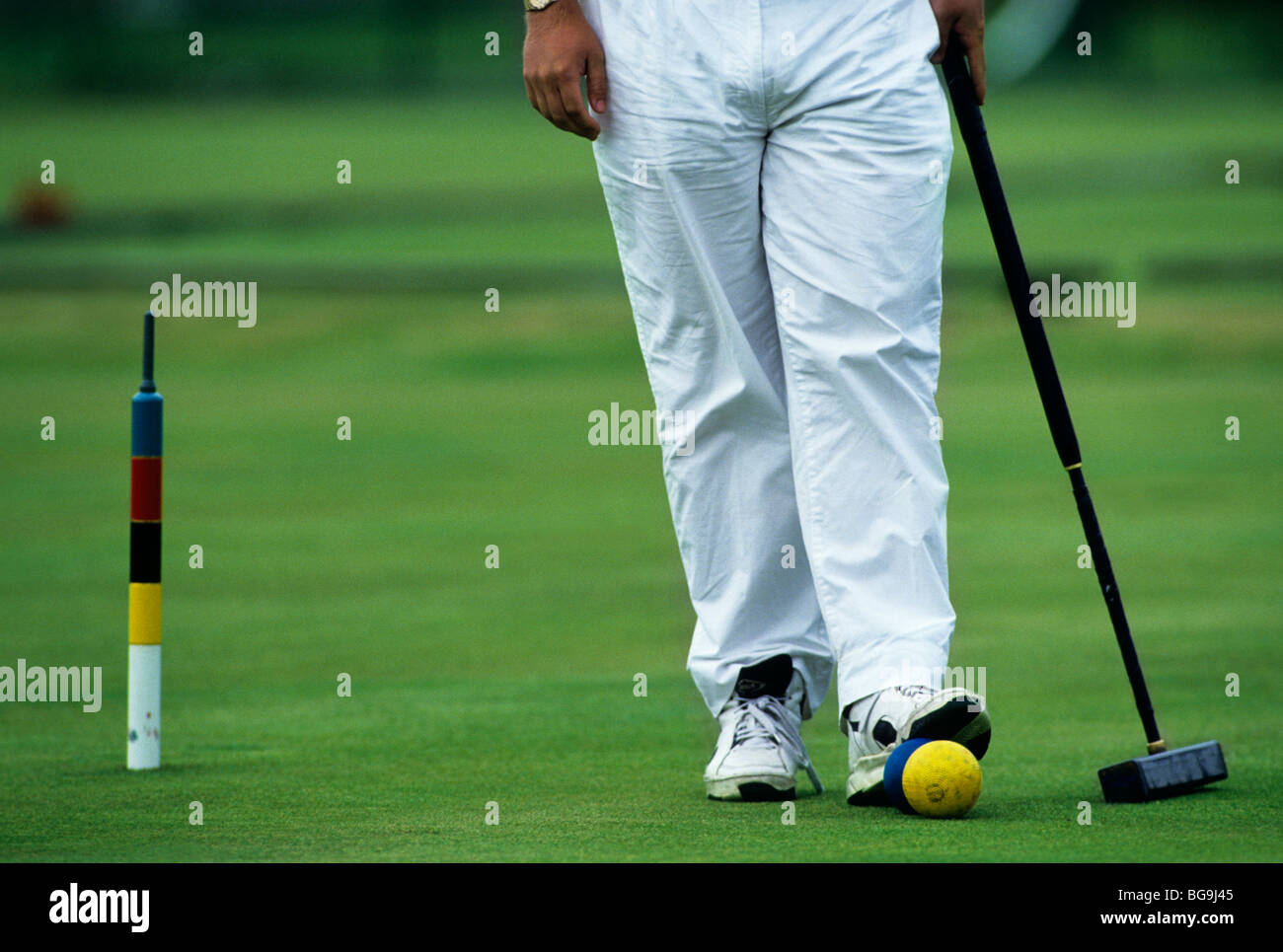 Croquet player with foot on croquet ball Stock Photo Alamy
