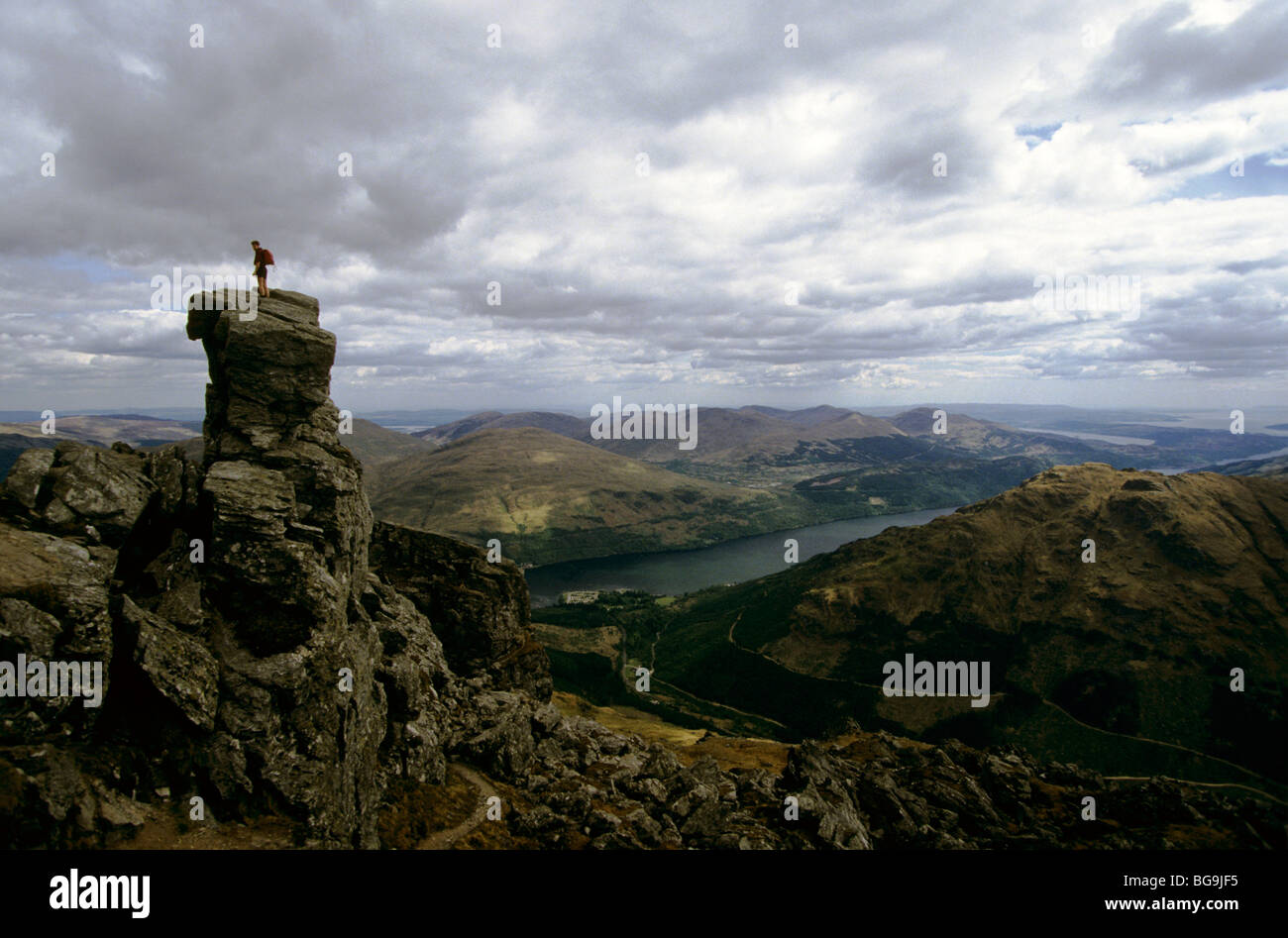 Hill walker on top of a crag Stock Photo