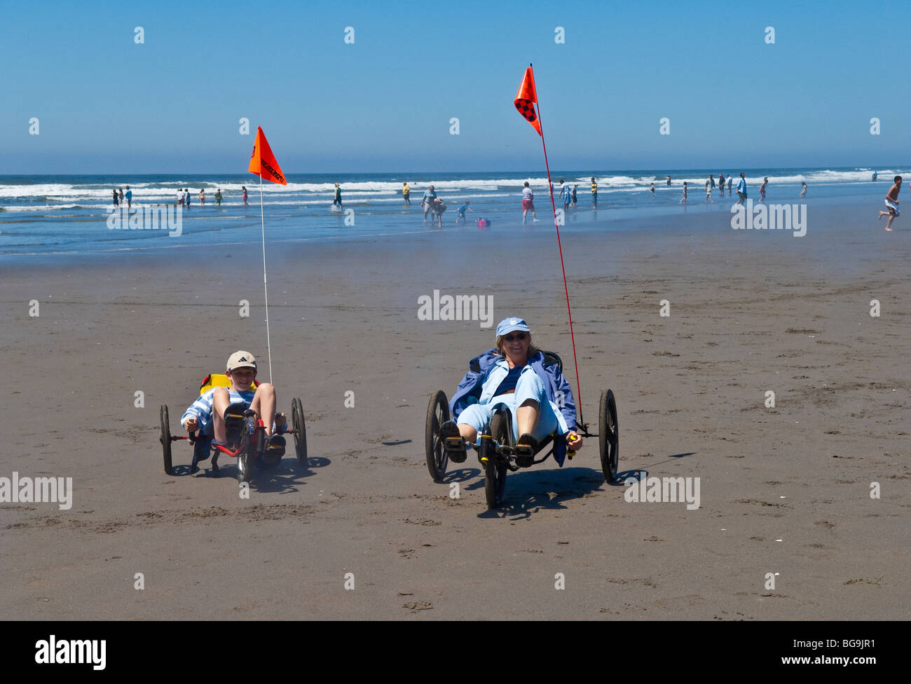Mother and son riding peddle trikes on the beach at Seaside, Oregon. Stock Photo