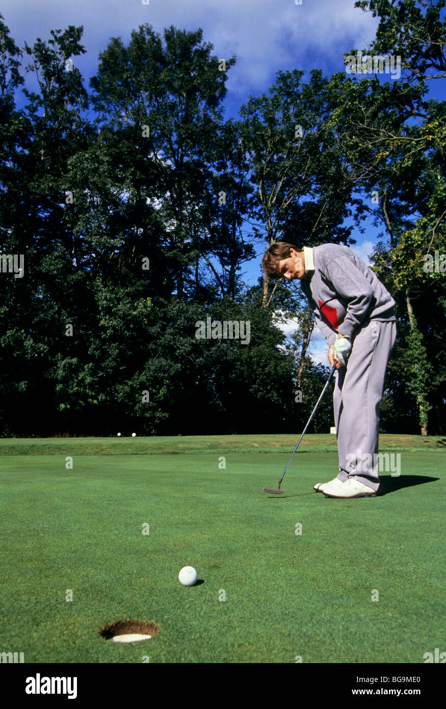 Golfer putting on the green Stock Photo Alamy