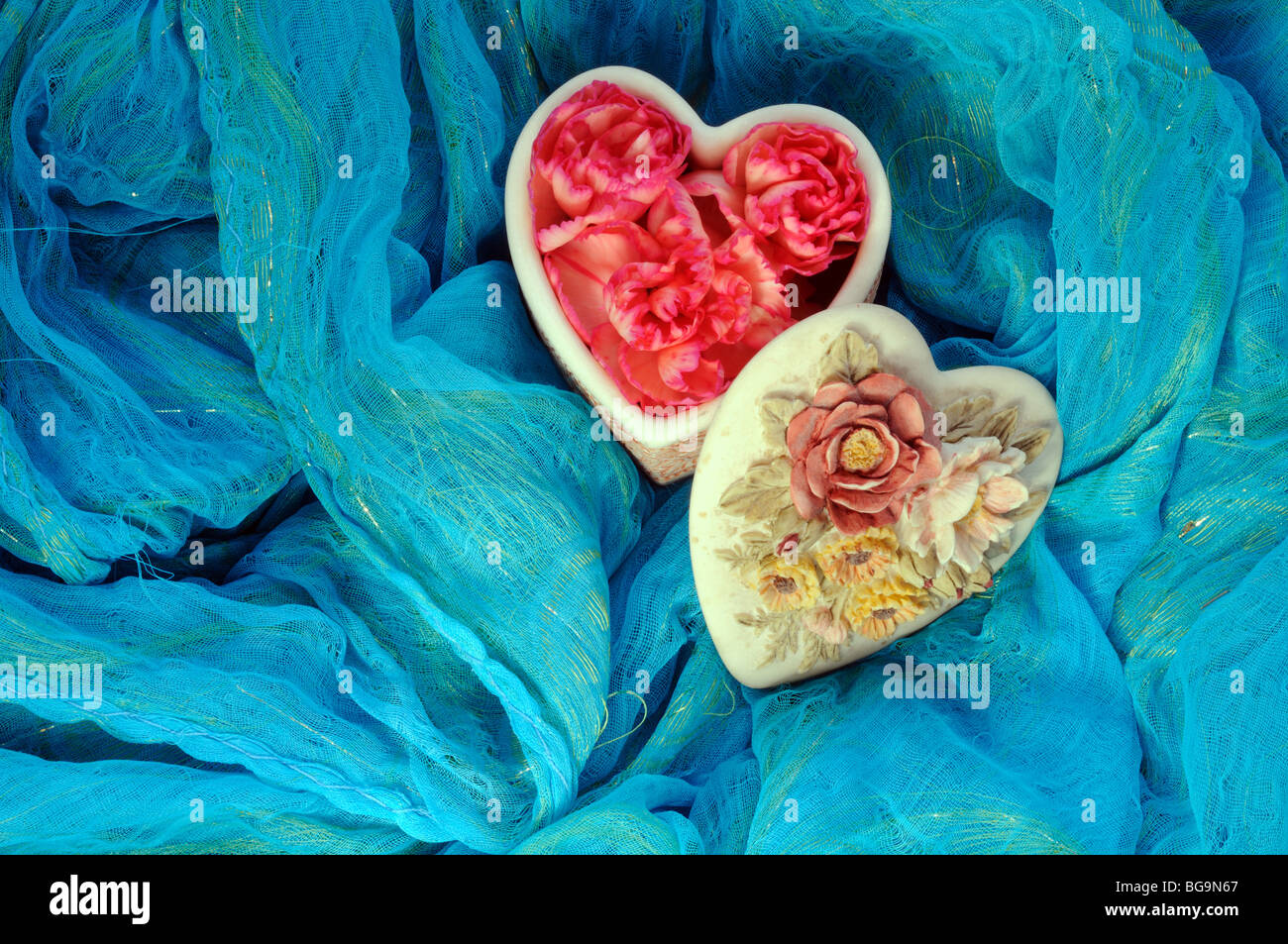 Heart shaped container with red petals Stock Photo - Alamy